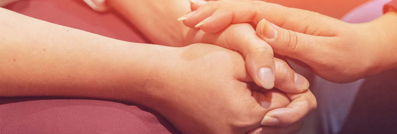closeup of support hand holding a couple of folded hands